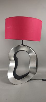 une lampe surmontée d'un abat-jour rose