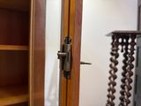 a close up of a door handle on a wooden cabinet