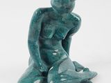 sculpture représentant un homme assis à genoux sur un fond blanc