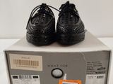 the black shoes are on top of a box on a white surface