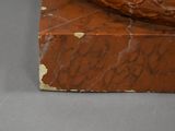 a brown sculpture of a snake on a marble block