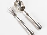two forks and a spoon on a white surface