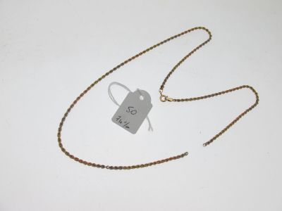 une photo d'un collier muni d'une étiquette, posé sur une surface blanche