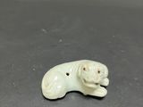 a small white dog figurine sitting on top of a table