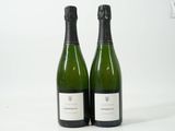 deux bouteilles de vin posées l'une à côté de l'autre sur une surface blanche