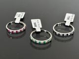 three rings with different colored stones on them sitting on a table