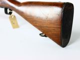 a close up of a wooden rifle with a tag on it