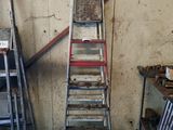 de nombreuses échelles empilées contre le mur