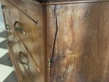 a wooden chest of drawers on a checkered floor