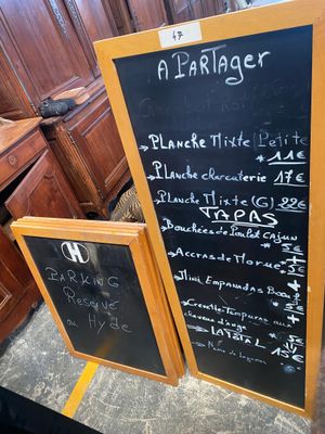 a blackboard with a menu written on it in front of some wooden cabinets