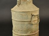 an old metal milk can sitting on top of a black table