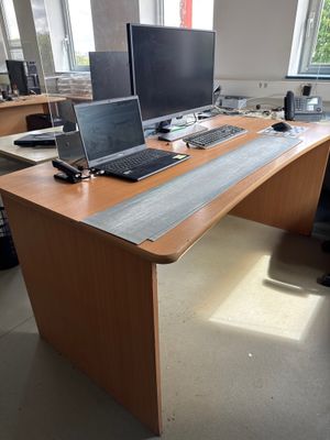a desk with two computers and a laptop on it