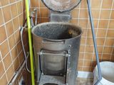 une poubelle et un balai dans un coin de la salle de bains