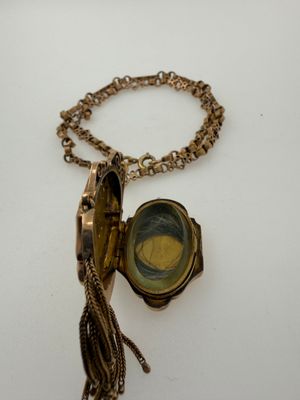a gold locke with a tassel attached to it