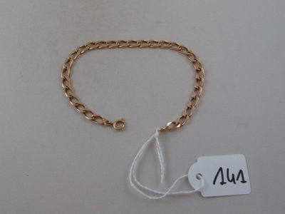 a close up of a gold chain bracelet with a tag on it