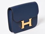 a blue purse with a gold h on the front
