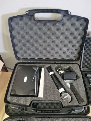 a black case with a microphone, a cell phone, and other items in it