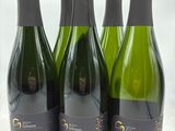 quatre bouteilles de vin sont alignées sur une table