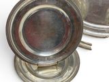 pair of silverplated dishes on stands on a white surface