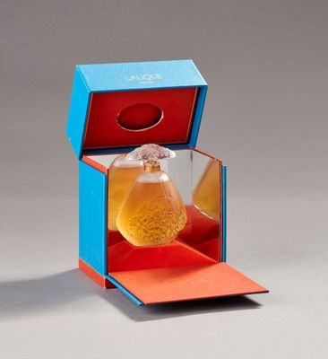 a bottle of perfume sitting inside of a blue box