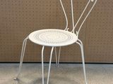 a white chair that is sitting in front of a wall
