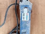 une perceuse électrique bleue posée sur une surface en bois