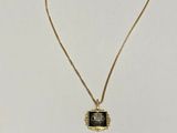 a gold necklace with a black stone pendant on it
