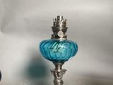 a blue glass vase and a silver vase on a table