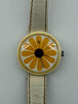 une montre ornée d'une fleur sur un fond blanc