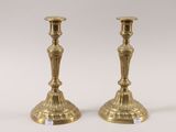 pair of antique brass candlesticks on a white background
