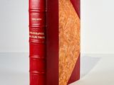 a red book sitting on a table with a white background