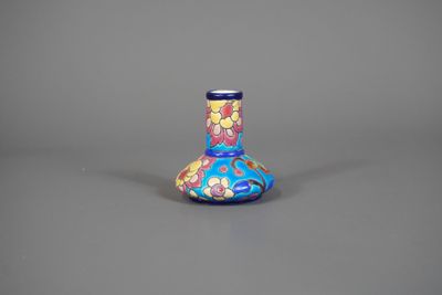 un vase bleu orné de fleurs, posé sur une surface grise