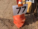 un cône de signalisation surmonté d'un panneau, à côté d'un tas de matériel de chantier