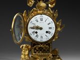 a gold clock with a bird on top of it