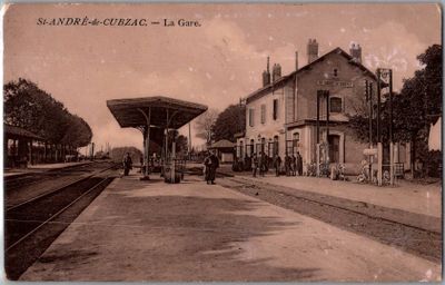 une vieille photo d'une gare où des gens attendent le train