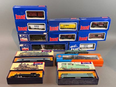 plusieurs trains miniatures dans leurs boîtes, empilés les uns sur les autres sur une table