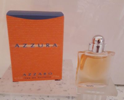 une photo montrant un flacon de parfum posé à côté d'une boîte sur un comptoir