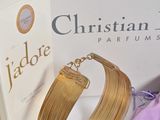 a gold bracelet and a purple bag next to it