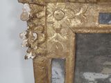 a mirror with a gold frame on the wall