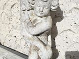 a statue of a woman hugging a cat on a wooden floor
