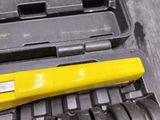 a yellow tool sitting on top of a black case