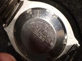 a person holding a watch in their hand on a black surface