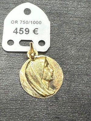 l'image d'une médaille d'or sur laquelle figure le visage d'une femme