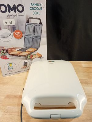 un grille-pain blanc posé sur une table à côté d'une boîte de nourriture