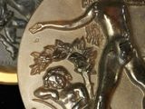 a silver coin with a picture of a woman and a man on it