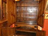 a wooden cabinet with a mirror and a rug on the floor