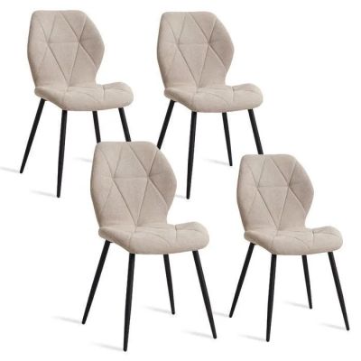 un lot de quatre chaises aux pieds noirs et à l'assise rembourrée beige