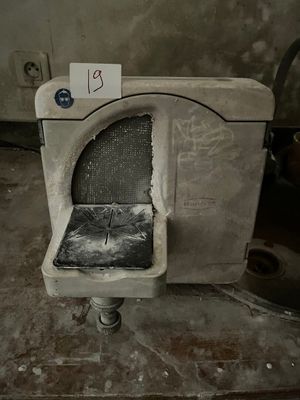 a dirty toilet in a dirty room with a price tag on it