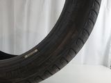 a tire on a white surface with a white curtain behind it