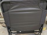 a black folding chair with a bag on top of it